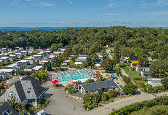 Vista aérea del parque de vacaciones Flower Camping Le Kerleyou en Bretaña, Francia, con piscina y casas móviles.
