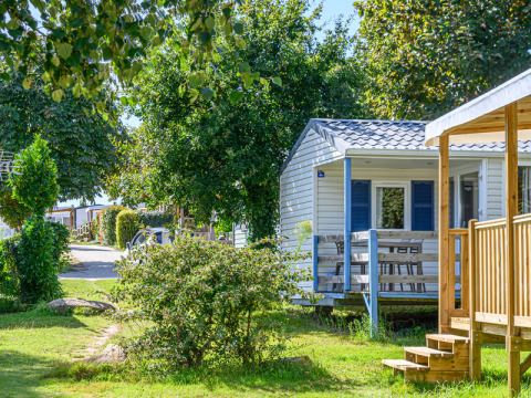 Mobile home and green surroundings at Flower Camping Le Kerleyou holiday park in Brittany, France, on a sunny day.