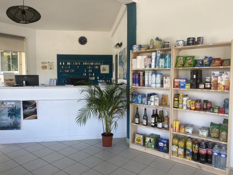 Reception area with a grocery shelf at Flower Camping Le Kerleyou holiday park in Brittany, France.