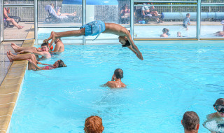 Children and adults enjoy the indoor swimming pool at Flower Camping Le Kerleyou in Brittany, France.