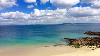 Prachtig uitzicht op zandstrand en blauwe zee bij Flower Camping Le Kerleyou in Bretagne, Frankrijk.