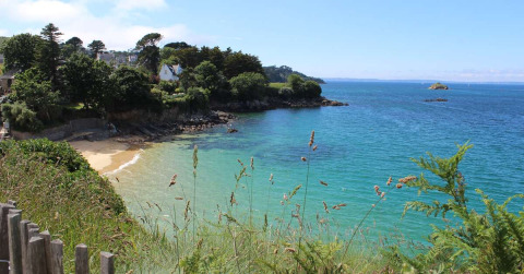 Beautiful coastal view at Flower Camping Le Kerleyou, Brittany, France, with blue sea and lush greenery.