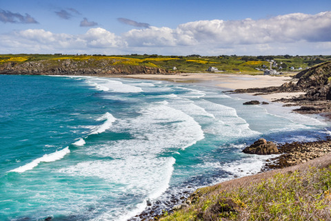 Paesaggio costiero con onde e spiaggia sabbiosa vicino a Flower Camping Le Kerleyou in Bretagna, Francia