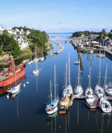 Luchtfoto van de haven van Douarnenez in Bretagne, Frankrijk, met zeilboten, een rood lichtschip en stad.