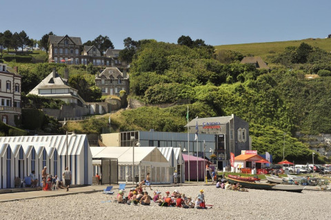 Gezinnen op het strand voor hutten en casino aan Flower Camping La Chênaie in Normandië, Frankrijk