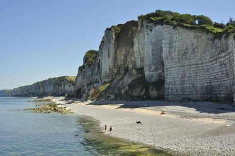 Beach and impressive chalk cliffs at Flower Camping La Chênaie holiday park in Normandy, France.