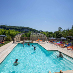 Buitenzwembad met ligzetels en parasols bij Flower Camping La Sagne, vakantiepark in Nouvelle-Aquitaine.