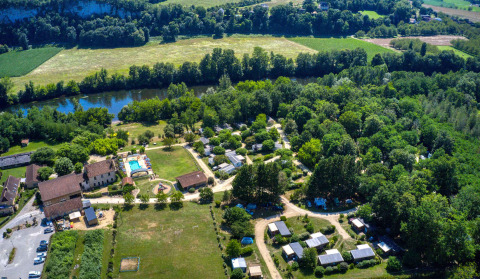 Luftaufnahme vom Flower Camping La Sagne Ferienpark in Nouvelle-Aquitaine, Frankreich, mit Fluss und Bäumen.