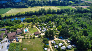 Vista aerea di Flower Camping La Sagne, parco vacanze in Nouvelle-Aquitaine, Francia, con piscina e fiume.