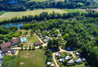 Vue aérienne du parc de vacances Flower Camping La Sagne en Nouvelle-Aquitaine, France, avec piscine et rivière.