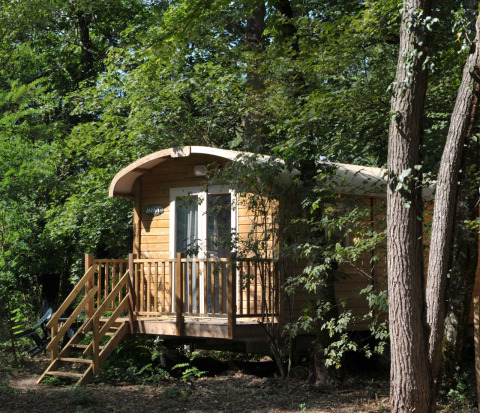 Holzhütte im Wald bei Flower Camping La Sagne, Ferienpark in Nouvelle-Aquitaine, Frankreich, im Sommer.