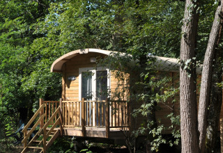 Houten hut in het bos van Flower Camping La Sagne, vakantiepark in Nouvelle-Aquitaine, Frankrijk, in de zomer.