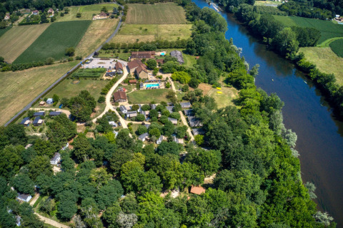 Vue aérienne du parc de vacances Flower Camping La Sagne en Nouvelle-Aquitaine, France, près d’une rivière.