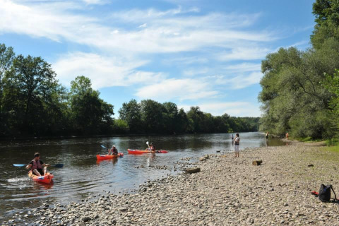 Personas en kayak y pescando en la orilla del río en Flower Camping La Sagne, Nouvelle-Aquitania, Francia.