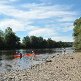 Mensen kanoën en vissen langs de oever bij Flower Camping La Sagne, Nouvelle-Aquitaine, Frankrijk.
