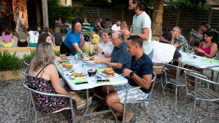 Ospiti gustano una cena all'aperto con musica dal vivo a Flower Camping La Sagne, Nouvelle-Aquitaine, Francia.