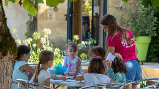 Bambini svolgono attività creative all'aperto a Flower Camping La Sagne, villaggio vacanze in Nouvelle-Aquitaine.