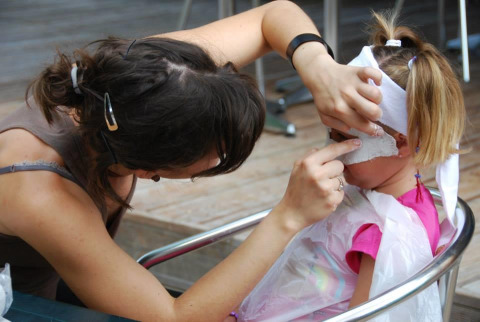 Un adulto hace una máscara facial a una niña en Flower Camping La Sagne, un parque de vacaciones en Nouvelle-Aquitaine, Francia.
