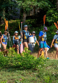 Groep wandelaars met reddingsvesten en peddels bij Flower Camping La Sagne, Nouvelle-Aquitaine, Frankrijk.