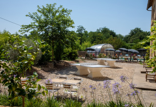 Outdoor leisure area with table tennis tables and a swimming pool at Flower Camping La Sagne, Nouvelle-Aquitaine.