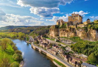 Luftaufnahme von Vitrac in Nouvelle-Aquitaine, Frankreich, mit Fluss, Altstadt und Burg auf Klippe.