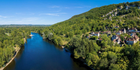 Luchtfoto van Flower Camping La Sagne met rivier, groene heuvels en dorp in Nouvelle-Aquitaine, Frankrijk.