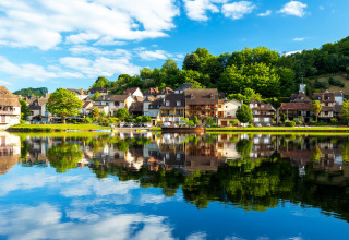 Panoramablick auf Vitrac in Nouvelle-Aquitaine, Frankreich, mit hübschen Häusern am ruhigen Fluss.