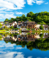 Vista panoramica di Vitrac in Nouvelle-Aquitaine, Francia, con case pittoresche riflesse nel fiume.