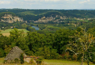 Blick über ein grünes Tal, Fluss und Hügel bei Flower Camping La Sagne, Nouvelle-Aquitaine, Frankreich.