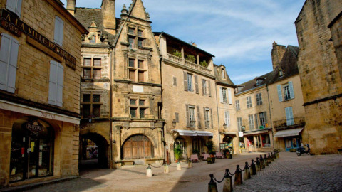 Place pittoresque entourée de bâtiments anciens près du Flower Camping La Sagne en Nouvelle-Aquitaine, France.