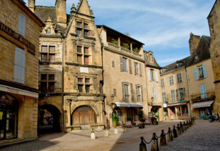 Place pittoresque entourée de bâtiments anciens près du Flower Camping La Sagne en Nouvelle-Aquitaine, France.