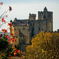 Un castello medievale circondato da foglie autunnali vicino a Vitrac, Nouvelle-Aquitaine, Francia.