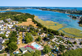 Luftfoto af Flower Camping Le Conleau feriepark i Bretagne, Frankrig, med swimmingpool og kystudsigt.