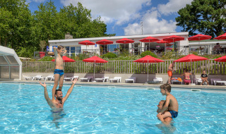 Feriecamping i Bretagne: Børn og voksne leger i swimmingpoolen på Flower Camping Le Conleau.