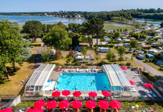 Vista aérea de la piscina y zona de acampada en Flower Camping Le Conleau, en Bretaña, Francia.