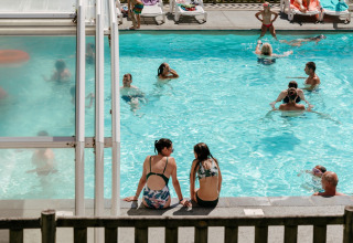 Menschen entspannen am sonnigen Pool im Flower Camping Le Conleau Ferienpark in der Bretagne, Frankreich.