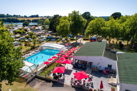Vista aérea de Flower Camping Le Conleau en Bretaña, Francia, con piscina, sombrillas rojas y caravanas.