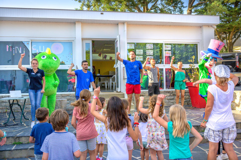 Enfants et adultes dansent et jouent avec des mascottes au Flower Camping Le Conleau en Bretagne, France.