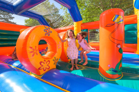 Dos niños juegan juntos en un colorido castillo hinchable en Flower Camping Le Conleau, Bretaña, Francia.