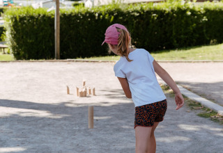 Kind speelt buiten op Flower Camping Le Conleau, een vakantiepark in Bretagne, Frankrijk, op een zonnige dag.