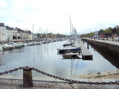 Boats docked at a pier in the harbor of Flower Camping Le Conleau, a holiday park in Brittany, France.