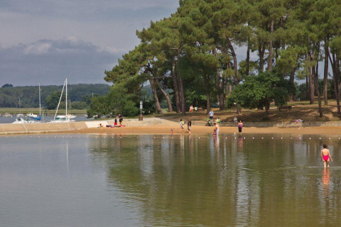 Persone si godono la spiaggia e gli alberi a Flower Camping Le Conleau, Bretagna, Francia.