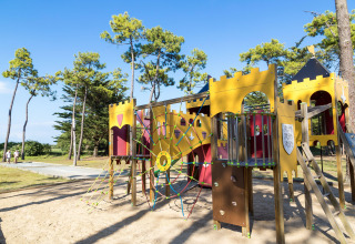 Kasteelthema speeltuin bij Flower Camping Tamarins Plage in Nouvelle-Aquitaine, Frankrijk, omgeven door bomen.
