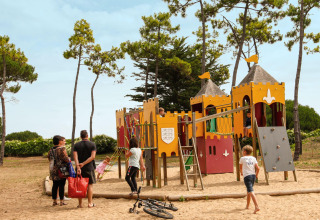 Kinder spielen auf einem burgähnlichen Spielplatz, während Erwachsene zusehen, im Tamarins Plage, Frankreich.