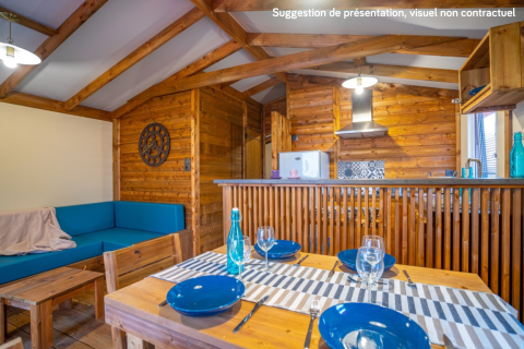 Binnenaanzicht van Lodge Premium VIP bij Flower Camping L'Ile d'Offard met houten interieur en eettafel.