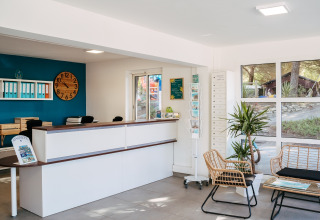 Reception area at Flower Camping Le Bois d'Amour in Brittany, France, featuring modern decor and cozy seating.