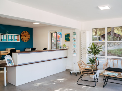 Reception area at Flower Camping Le Bois d'Amour in Brittany, France, featuring modern decor and cozy seating.