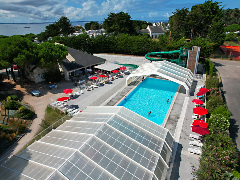 Aerial view of the pool, water slide, and sunbeds at Flower Camping Le Bois d'Amour in Brittany, France.