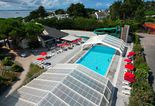 Vista aerea della piscina, scivolo e lettini al Flower Camping Le Bois d'Amour in Bretagna, Francia.