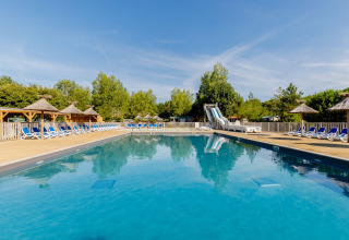 Udendørs swimmingpool med liggestole og vandrutsjebane på Camping Demoiselles Plage, Pays de la Loire, Frankrig.